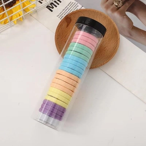 Detailed macro view of colorful high-elastic hair ties in a clear cylindrical storage container