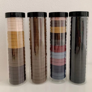 Detailed view of seamless elastic hair ties stored in four clear tubes with black caps