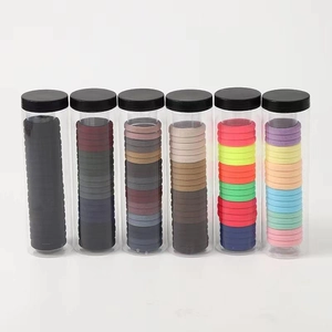 Macro detail of six transparent jars filled with various colorful high-elasticity hair ties
