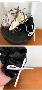 Close-up of silk satin scrunchie with ribbon bow and detailed overlock stitching edges