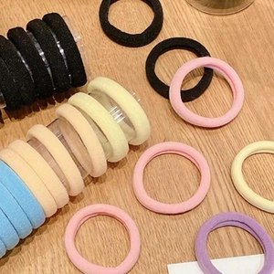 Macro shot of seamless elastic hair ties in pastel macaron colors on a wooden surface
