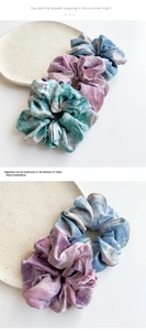 Close-up of satin scrunchies with marble tie-dye patterns in blue and pink tones