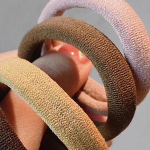 Close-up of high elasticity seamless hair ties in assorted earth-tone knitted fabrics