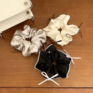 Three-pack satin ribbon bow scrunchies in grey, beige, and black colors for hair styling