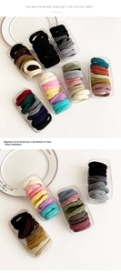 Macro shot of high-elastic seamless hair ties in a transparent storage box container