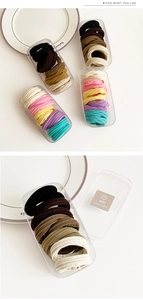 Detail of durable seamless hair ties in various colors with minimalist storage case