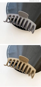 Detailed view of large matte hair claws in dusty purple and khaki finish for styling
