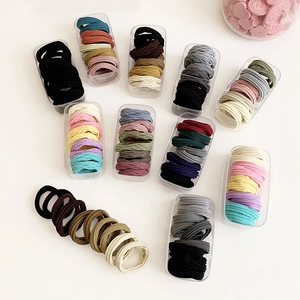 Elastic seamless hair ties set in various pastel colors organized in plastic boxes