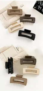 Detailed close-up of four matte rectangular hair claws in neutral earth tones and textures