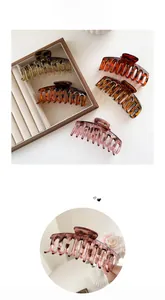 Detailed view of amber and pink glossy resin large hair claws in minimalist bone design
