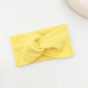 Detailed view of yellow ribbed knit headband with center twist knot texture