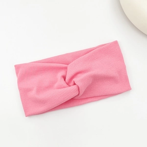 Detail of pink ribbed knit texture and twisted knot design on the elastic headband