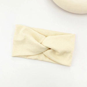 Close-up of cream ribbed knit headband featuring a classic central knotted design