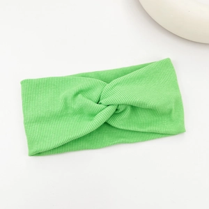 Close-up of mint green ribbed knit yoga headband featuring a classic twisted knot detail