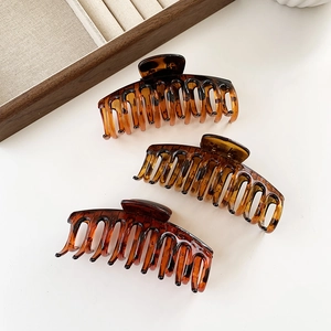 Three amber tortoise shell large hair claw clips set in a minimalist geometric bone design