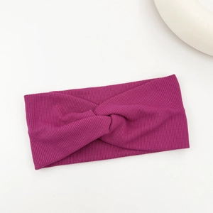 Detail view of burgundy ribbed twist headband with elastic fabric for yoga and sports