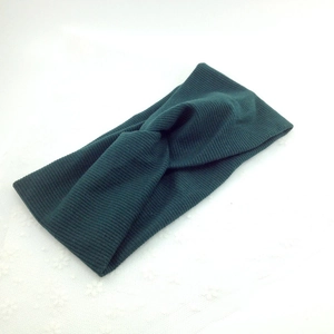 Detail view of dark green ribbed elastic headband with a stylish twist knot design