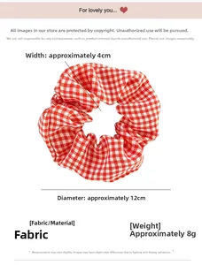 Detailed view of red gingham pattern fabric scrunchie with soft cotton texture