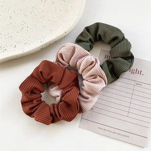 Three-pack ribbed velvet scrunchies in green, pink and red colors for ponytail