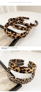 Close-up of thick leopard print headband with handmade label and soft fabric texture