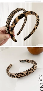 Detail of a handmade leopard print headband with soft fabric texture and inner woven label