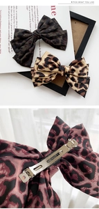 Dettaglio dei fermagli per capelli in raso leopardato con clip in metallo fatti a mano
