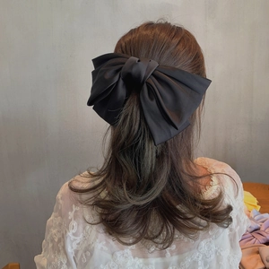 Grande pince à cheveux élégante avec nœud noir pour cheveux épais, portée sur une femme