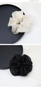 Detail von Mesh-Haargummis mit glitzernden Strasssteinen in Beige und Schwarz