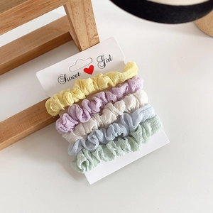 Set of five pastel scrunchies in yellow, purple, white, blue, and green on display card
