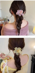 Detail of flower hair claw clip on braided hair showing pink resin and matte texture