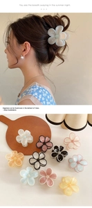 Detail showing various pastel color flower hair clips and model styling the floral claw clip