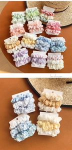 Détail de chouchous en tissu à motifs floraux et carreaux présentés sur un support bois