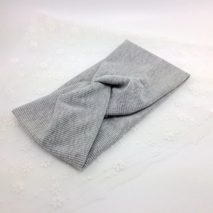 Elastic light gray ribbed knit sports headband with a twist knot on white lace
