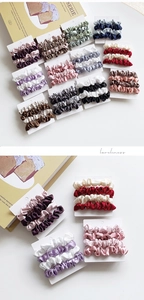 Close-up of premium satin scrunchies set in elegant colors on a white display card