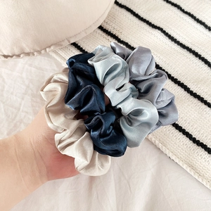 Lot de quatre chouchous en satin en champagne, bleu marine, bleu et gris texture douce