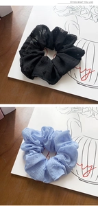 Dettagli degli scrunchie in organza neri e azzurri con motivi a pois in rilievo