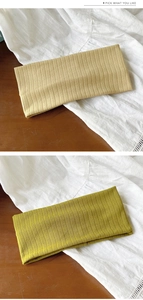 Détail de bandeaux en tricot jaune et vert avec des motifs ajourés en forme de losange