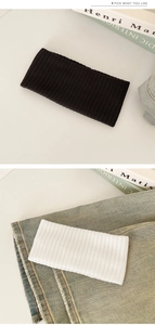 Detail of ribbed knit headband showing fine vertical texture in black and white colors