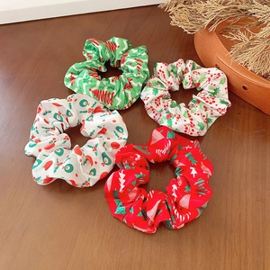 Weihnachts-Haargummis Set mit festlichen Mustern auf einem warmen Holzhintergrund