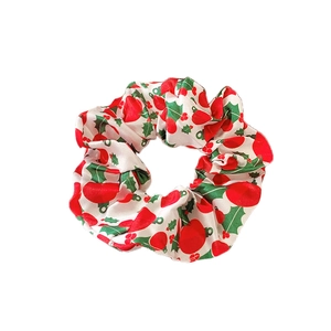 Weihnachts Haargummi mit roten Stechpalmenbeeren und grünen Blättern auf weißem Satin