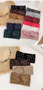 Detailed macro view of ribbed knit twisted headbands in twelve colors with pearl accents