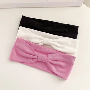 Three elastic knit bow headbands in pink, white, and black for yoga and sports styling