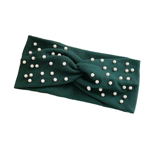 Dark green ribbed knit headband with elegant white pearls and a stylish knot design