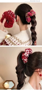 Detail of red plush scrunchie and houndstooth pattern tie on hair bun and ponytail