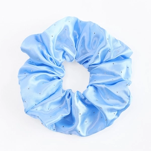 Gros plan sur chouchou en satin bleu clair avec strass brillants et plis soyeux