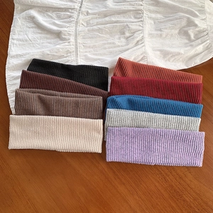 Nine colorful elastic knitted ribbed headbands for yoga and skincare on wooden table