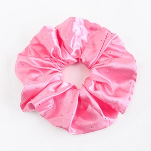 Détail d'un chouchou en satin rose avec strass brillants pour coiffures élégantes