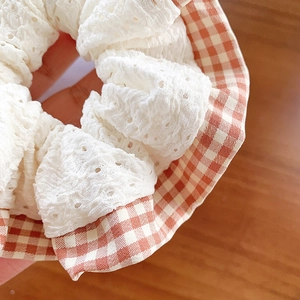 Sweet lace and plaid scrunchie with intricate embroidery on a wooden surface