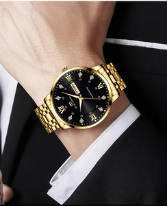 Detail of luxury men's gold watch with black dial and calendar worn with business suit