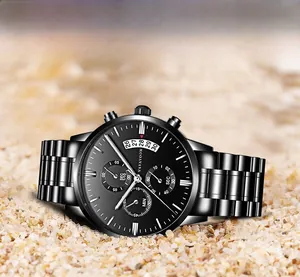Close-up of black stainless steel chronograph watch with calendar display on sand background